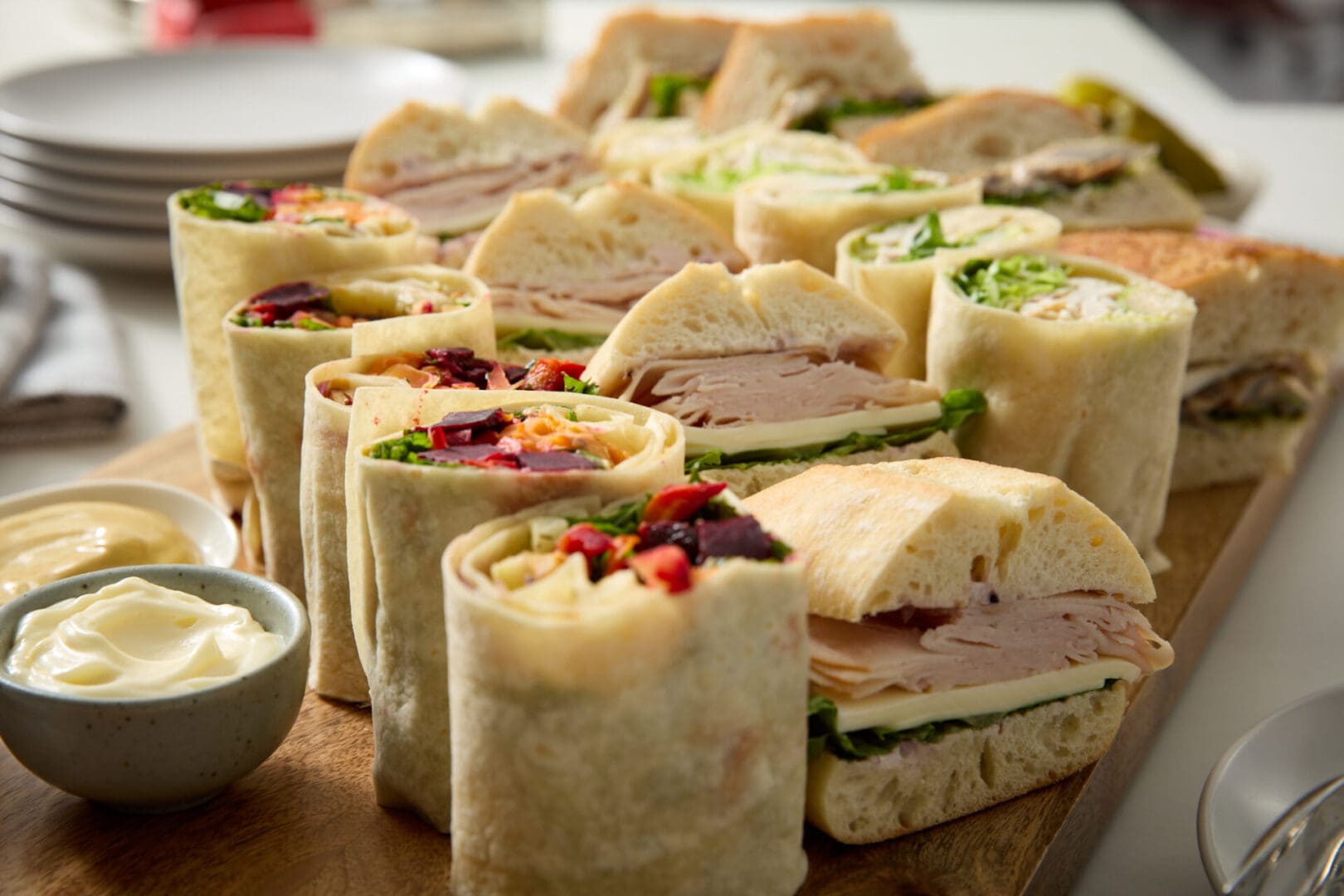 A wooden table topped with sandwiches covered in bread.